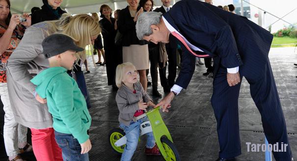 Kerry talks to Smilte Kuzmickaite, 3, as her mother Sigita (left) and brother Kristijonas, 6, watch during Kerry's visit to the U.S. Embassy in Vilnius, Lithuania, on Sept. 7. | Reuters