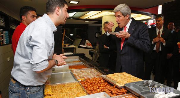 Kerry (right) samples some dessert as he visits a shop in the West Bank city of Ramallah on May 23. | Reuters