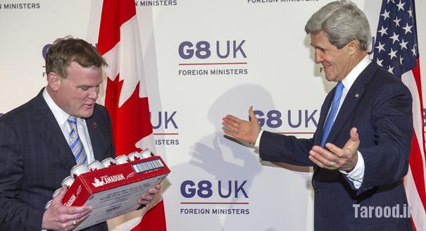 Canada's Minister of Foreign Affairs John Baird (left) offers a case of Molson Canadian beer to Kerry, to pay off a gentlemen's bet on a women's hockey tournament that the U.S. had won, in London on April 11. | Reuters