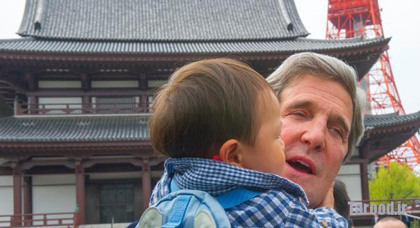 Kerry holds a child as he tours the Zojoji Buddhist Temple in Tokyo on April 14. | Reuters